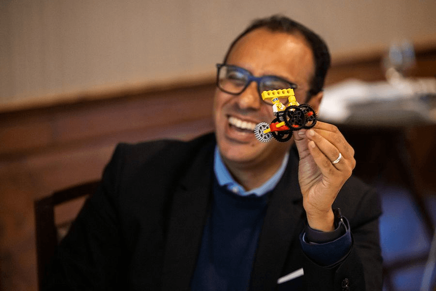 A person showing a Lego car they built during a presentation of the i5 Playbook.