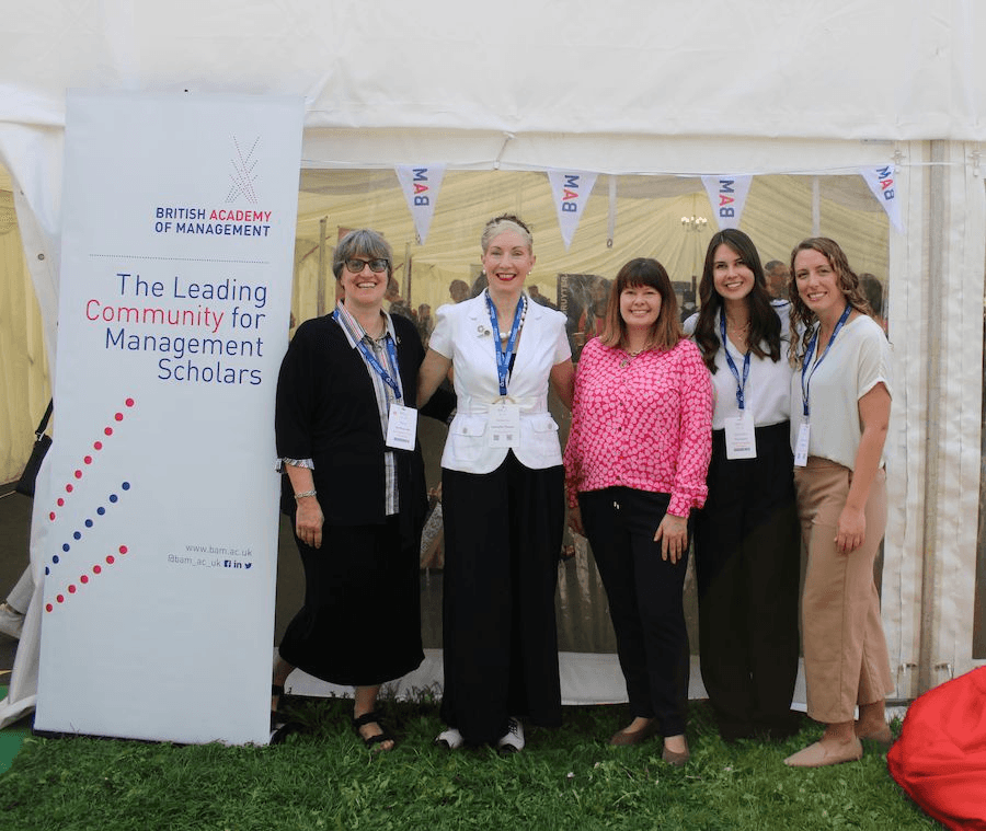 PRME representatives pose outside with members of the British Academy of Management next to a tent.